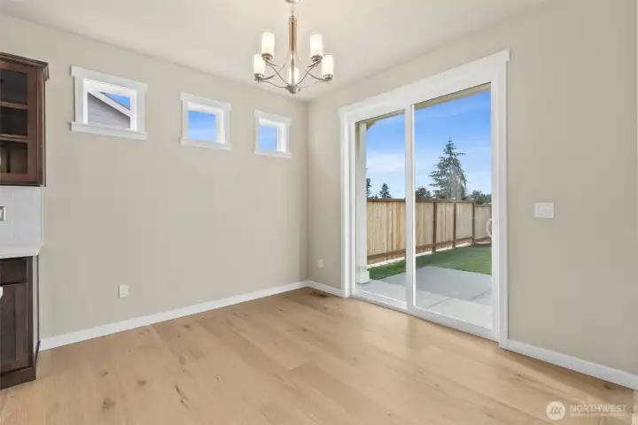Dining area features hardwood flooring and a glass slider that opens to backyard  and patio area.
