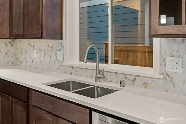 Kitchen with clean contemporary design features double stainless steel undermounted sink and full tile backsplash.
