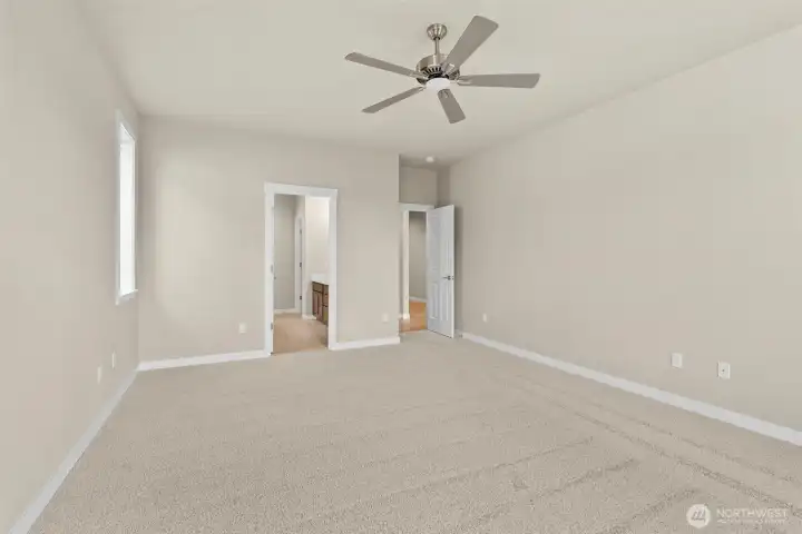 Large primary bedroom featuring a standard ceiling fan for comfort.