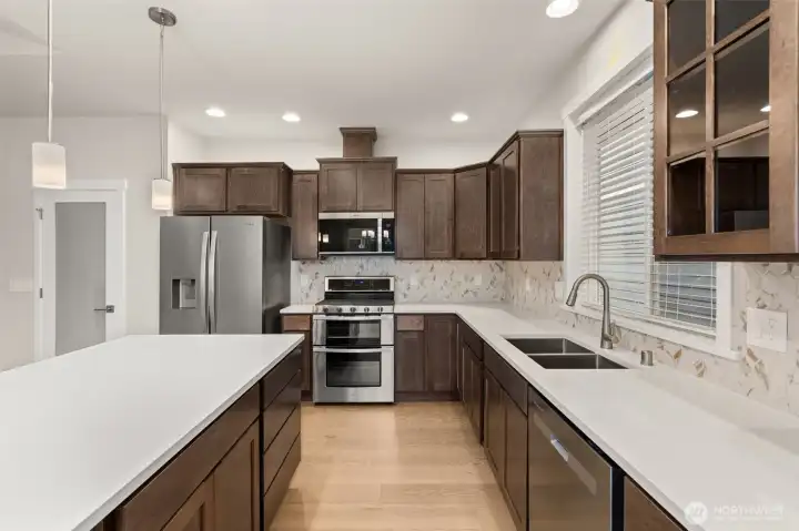 Beautiful quartz countertops and full tile backsplash. Frosted door leads to pantry.