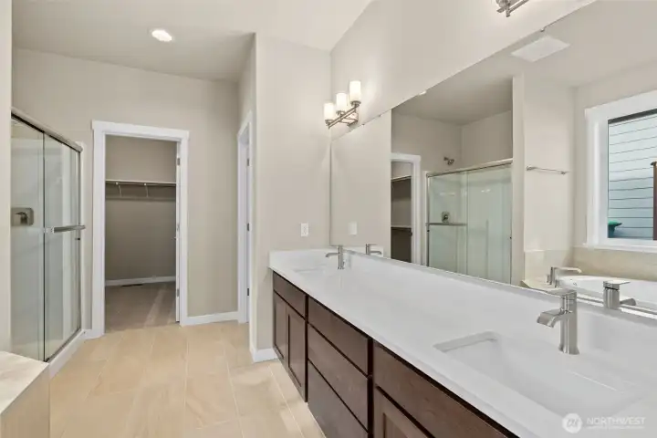 Primary bath is stunning with a double vanity with undermount sinks and tile backsplash.
