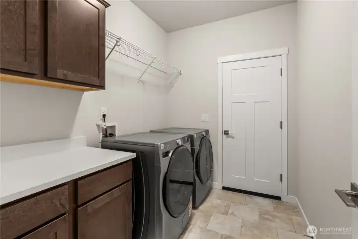 Separate laundry room with a counter, storage cabinets and a storage shelf above appliances. Washer and Dryer are included.