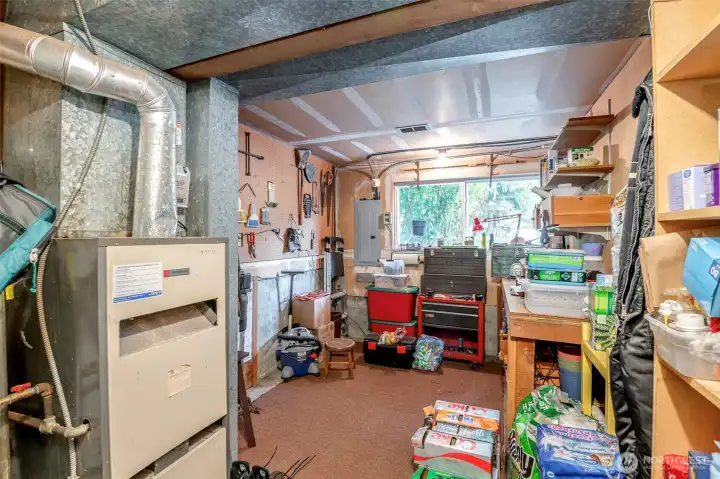 Bottom floor has tool area, furnace, storage and electrical panel.