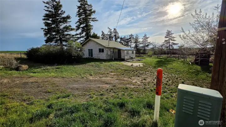 Looking SW from the NE corner of the house near the driveway: Notice the fiber line ready to be connected! Enjoy the peaceful seclusion of country living without sacrificing the modern convenience of super high-speed internet.