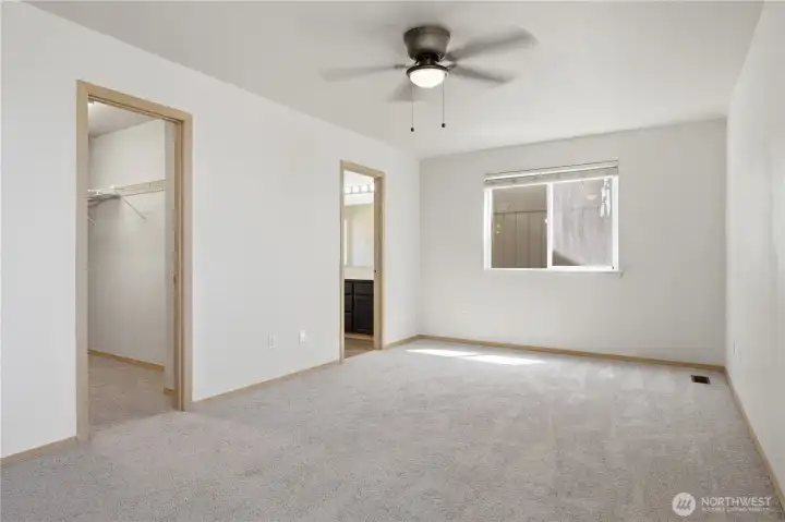 The primary bedroom is generously sized with walk-in closet, bathroom ensuite, bright windows and ceiling fan for year round comfort