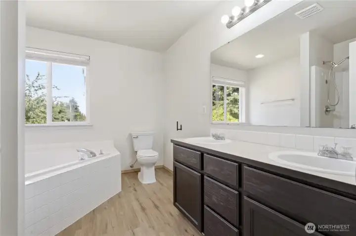 Primary bathroom with double vanities, deep soakng tub, and walk-in shower