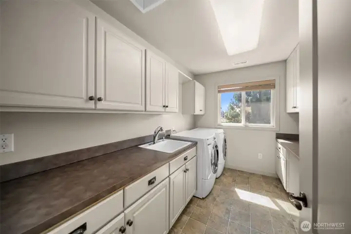Laundry Room on Upper Floor with Front Load Washer and Dryer and Plenty of Storage and Folding Counters