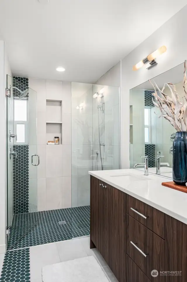 A closer look at the shower area, with sleek glass doors and stylish tile work.