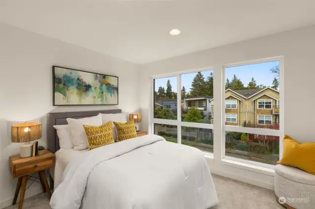 Relax and unwind in this sunlit bedroom, featuring large windows that frame picturesque neighborhood views. Plush carpeting and modern decor make it the perfect retreat to end your day.