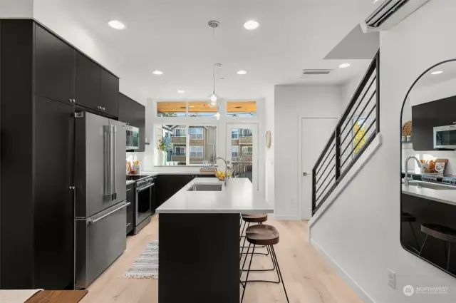 Step into the heart of the home! This sleek, modern kitchen boasts high-end finishes, a spacious island, and stainless steel appliances – perfect for culinary creations.