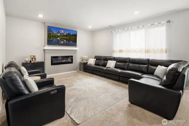 A larger living room with nice carpeting and fireplace. Big dual pane windows looking into the backyard.