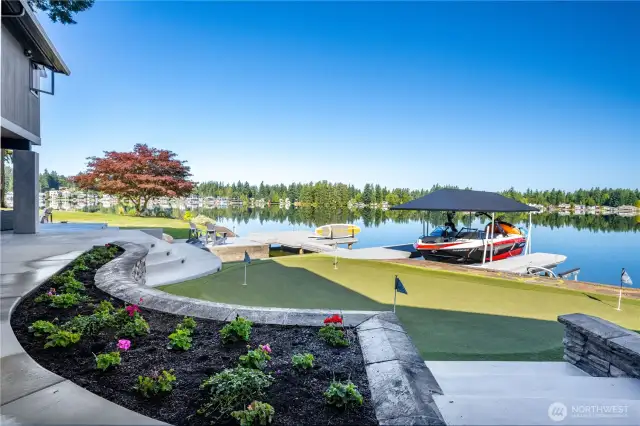 Side yard perspective of the 4 hole putting green and the two docks connected by the bridge Both the boat and jet ski lifts are solar powered