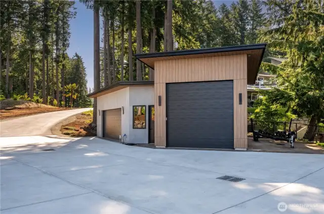 The detached shop with 12’ high garage door. Amazing exterior as well as concrete panels. The material is called Trespa. Google it. It is iron clad.