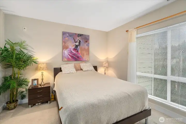 Serene primary bedroom with large window and lots of natural light.
