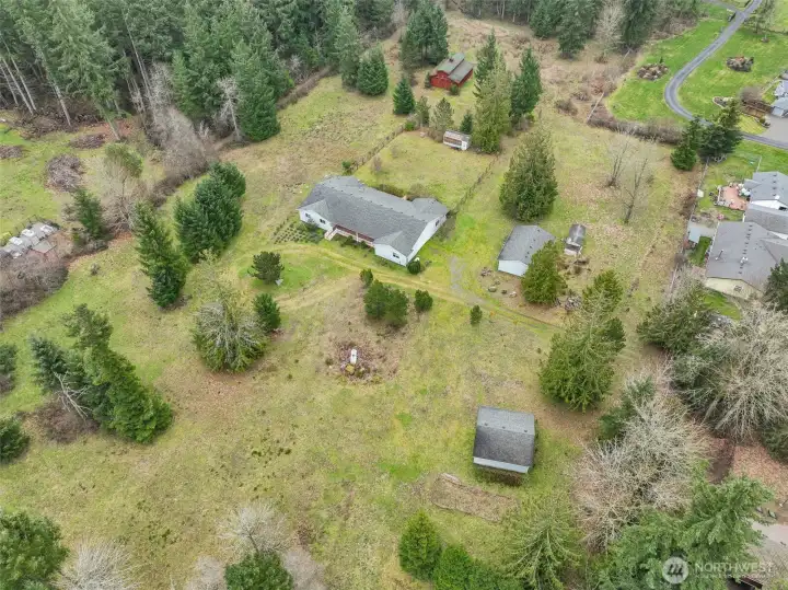 Here is a great view that shows the fenced yard off of the back of the house and the positions of the outbuildings on the property.