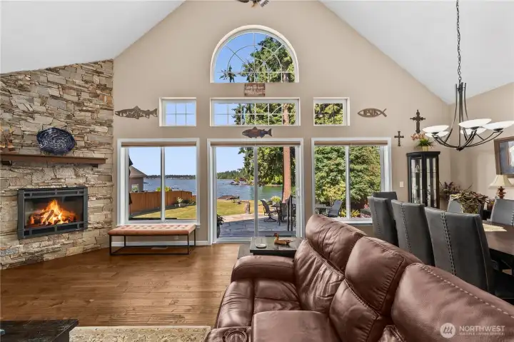 Great room with vaulted ceilings, floor to ceilings windows and stone fireplace.