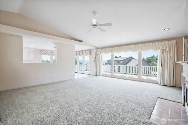 Living room open to dining, and kitchen and deck