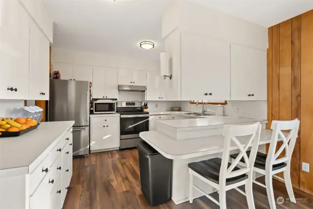 The kitchen truly serves as the heart of this home, combining warmth and functionality. With updated lighting and crisp white cabinets, the space feels light, bright, and inviting—making it the perfect setting for preparing meals or entertaining or simply enjoying a meal