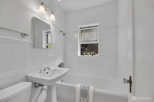 Penny tile floor, marble accents, & tile walls make the bath so cute.