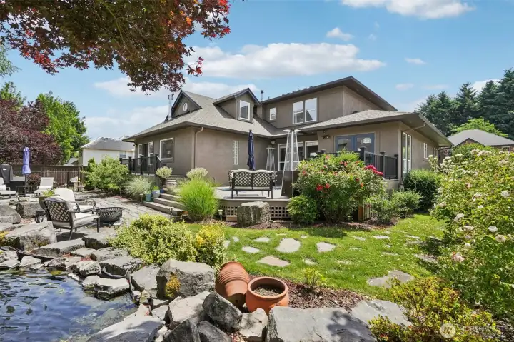 peaceful back yard with outdoor speaker, 500+ sq ft deck with multi levels and natural gas grill hook ups
