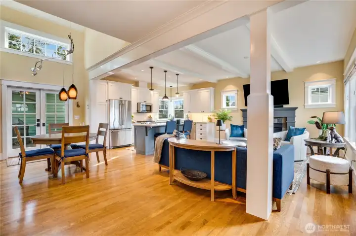 Step inside to a bright, open layout featuring quarter-sawn oak floors, fully wrapped trim around the windows, deep baseboard detail, beamed ceilings with crown molding, and thoughtful architectural details throughout.