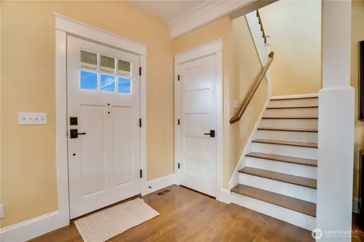 Custom millwork, crown molding, and thoughtful architectural details shine at every turn. On the way upstairs, a handy coat closet and discreet under-stair storage add everyday ease, while quarter-sawn hardwood stairs elevate the custom craftsmanship.