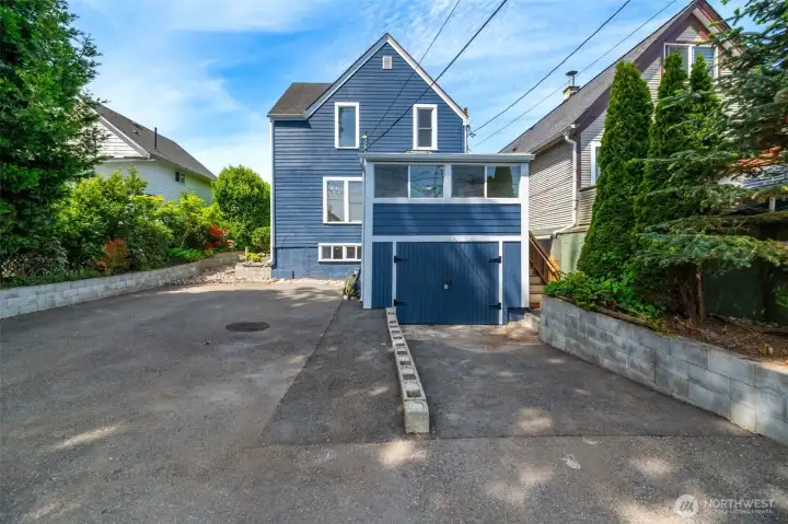 Another view of the back of the home. The landscaping is mature and fairly low maintenance. There is an area to the right that could be used as a raised garden.
