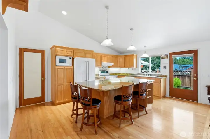 Main home kitchen with entrance to ADU to the left and exit to patio to the right.