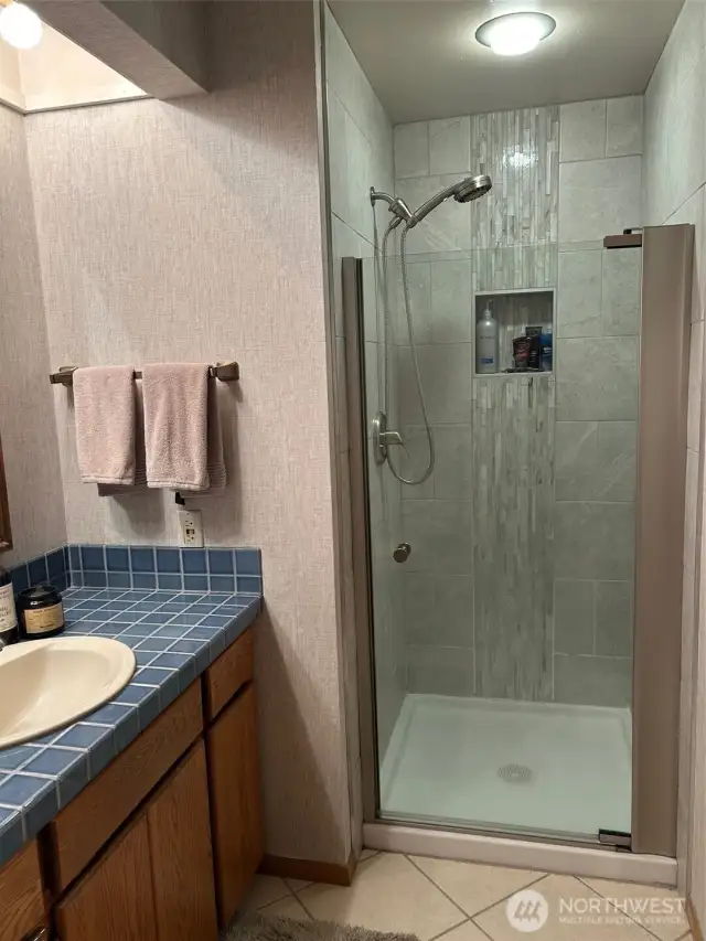 Attractive tiled shower surround in guest bath.