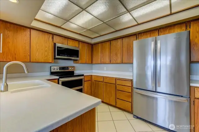 Efficient kitchen with Corian countertops, stainless appliances and a pantry.