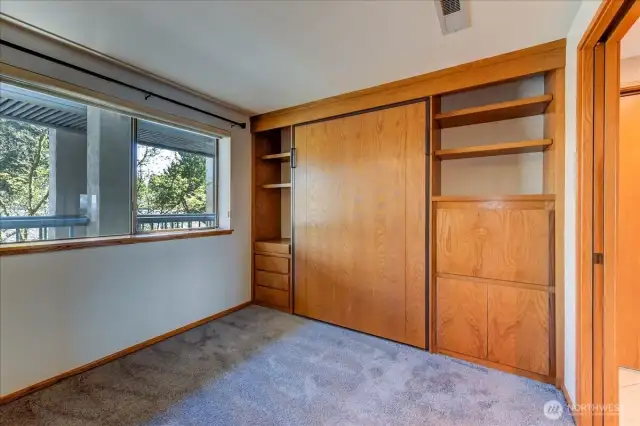 Double sliding door entry to bedroom #2.  Complete with black out shades, display and storage cabinetry.