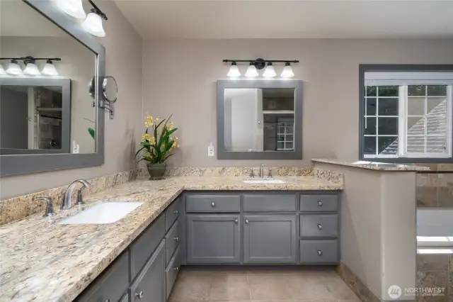The primary bathroom offers ample room and double sinks, combining luxurious finishes with bright, natural light—creating a comfortable and elegant space perfect for busy mornings and shared routines.