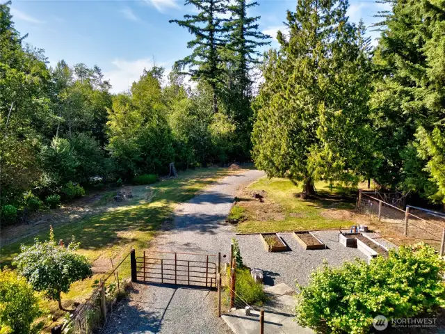 A fully fenced garden area includes raised garden boxes, frost-free water faucets, and electrical access, making it turnkey for planting, irrigating, and working year-round. A cement pad is in place—perfectly suited for a chicken coop, greenhouse, or small shed.    Just beyond, an additional fenced area offers potential for a paddock, ideal for goats, sheep, or other small livestock—bringing rural flexibility and future growth opportunities to your backyard.