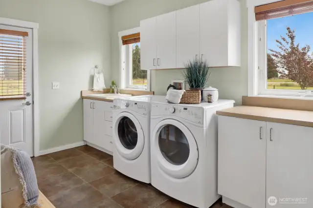 The spacious mudroom/ laundry room has a door to the side of the home