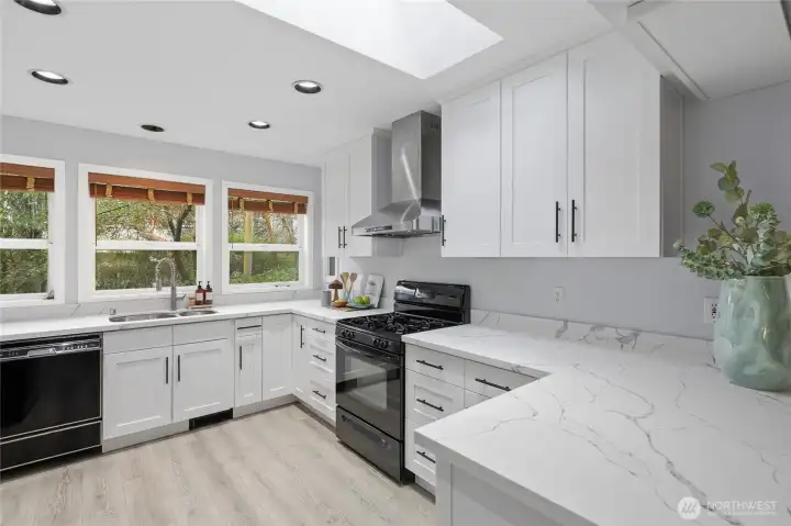 White cabinetry with gas cooking and enough storage to keep counters clear.