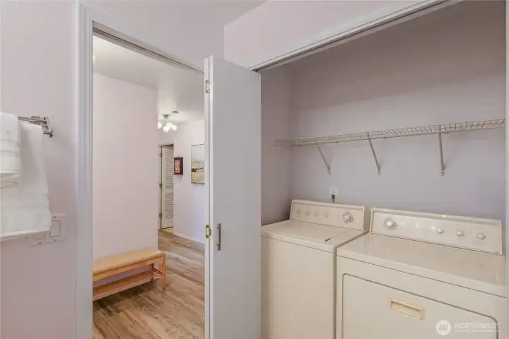 Lower floor laundry with built-in shelving and storage.