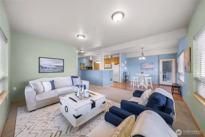 Open floorplan connects the living, dining, and kitchen areas, where natural light flows in from 3 sides.