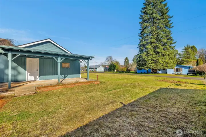 Back of garage with a covered deck and a door to the back of the garage