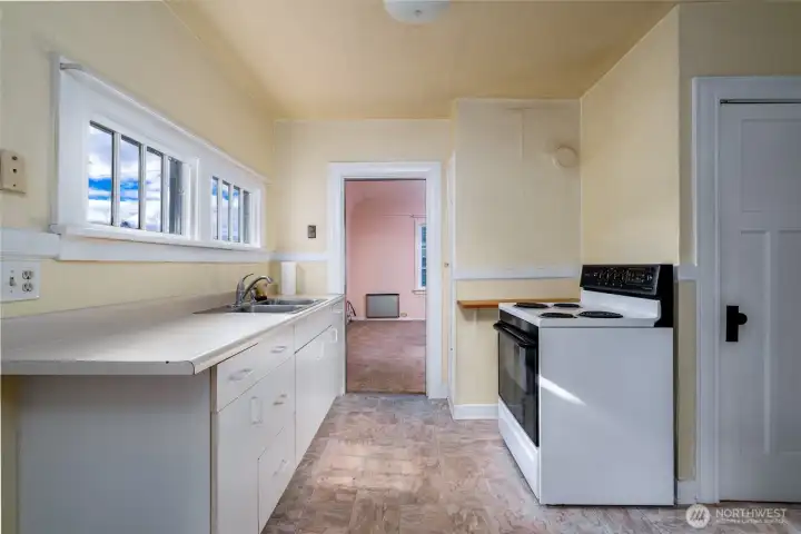 Kitchen overlooks backyard. Linoleum floors for easy cleanup.