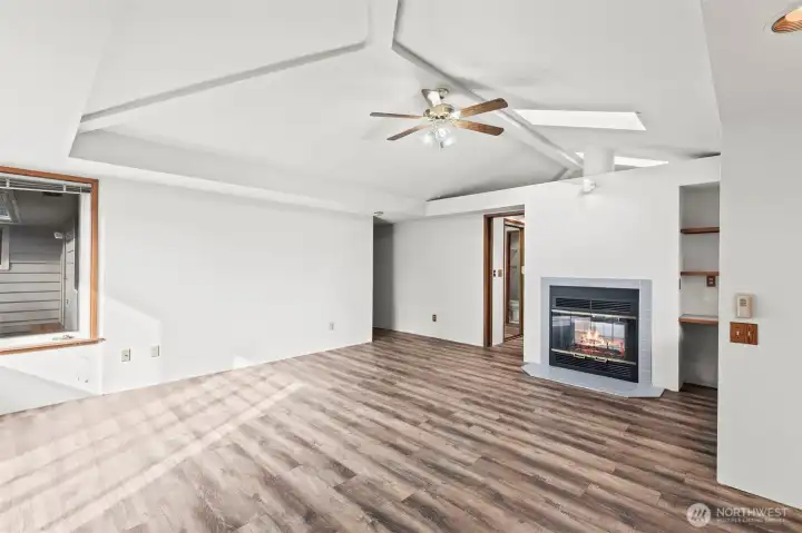 Brand new flooring in primary bedroom with vaulted ceilings and fireplace with on suite