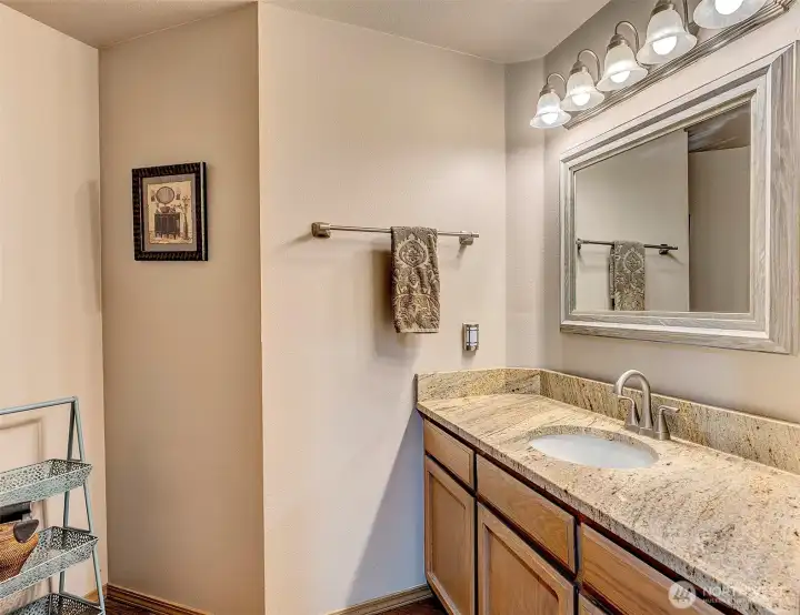 Main level half bath with newer granite counter.