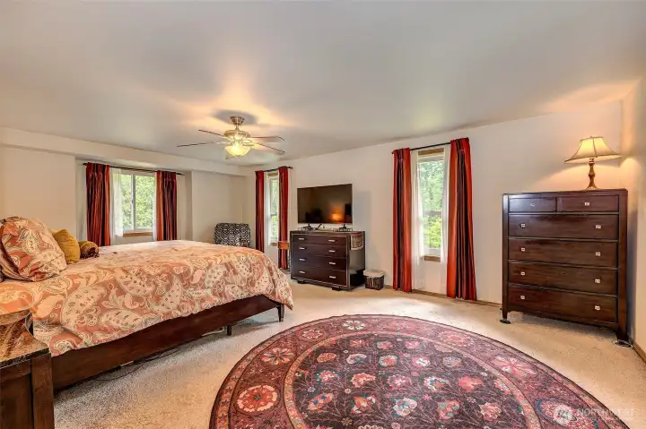 Upper level primary bedroom with a private deck over looking the tranquil back yard.