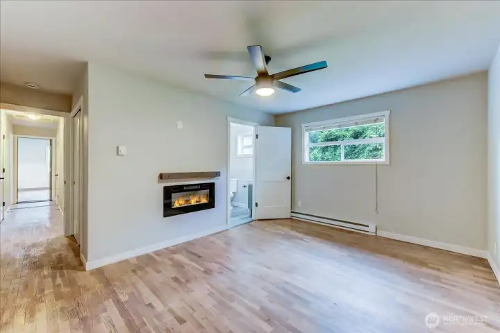 Electric fireplace with wood beam mantel in primary bedroom Electric fireplace with wood beam mantel in primary bedroom