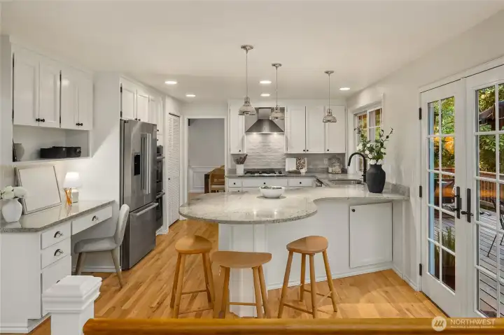 Newly refinished and repainted cabinetry with thoughtful storage, and premium stainless steel appliances including Bosch double wall ovens and Bosch fridge as well as a pristine Miele dishwasher.