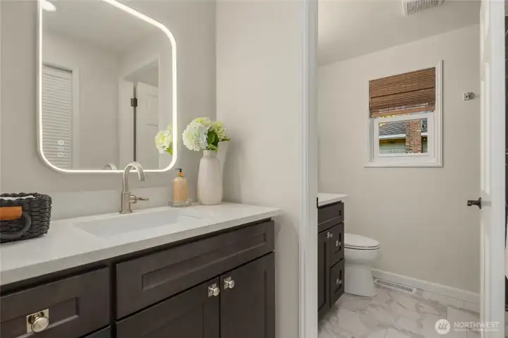 Completely refinished primary bath space - all new dark stained custom cabinetry with elegant, polished nickel hardware, new Kohler plumbing fixtures, toilette and gorgeous porcelain clad shower. Easy to maintain and stunning porcelain flooring. New LED make-up mirror.