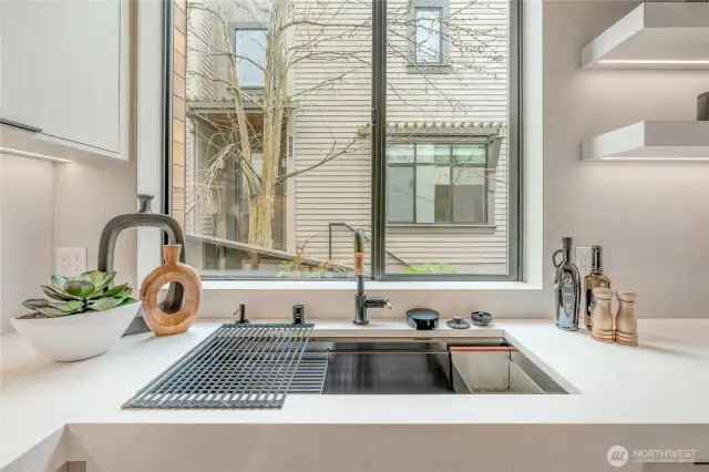 The oversized sink, equipped with a convenient cup washer, makes kitchen tasks a breeze.