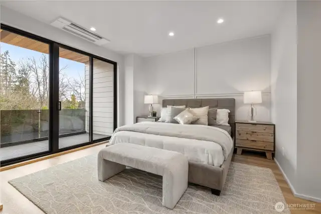 The large primary bedroom features a sliding door that opens to a private deck, offering a personal outdoor escape.