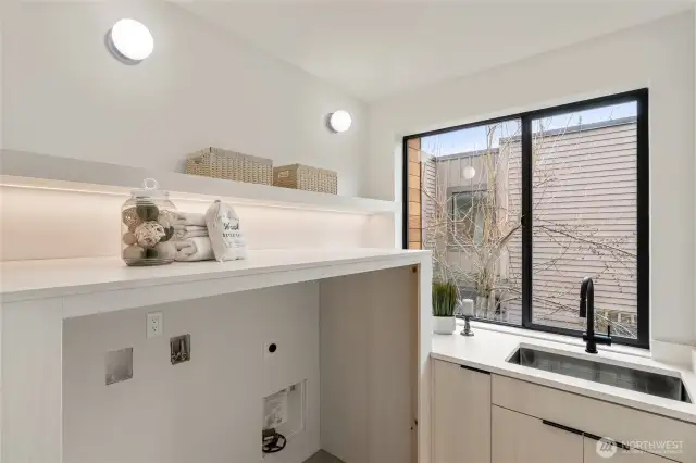 Bright Utility Space: The large laundry room features a utility sink and a generous window, providing ample light and functionality.