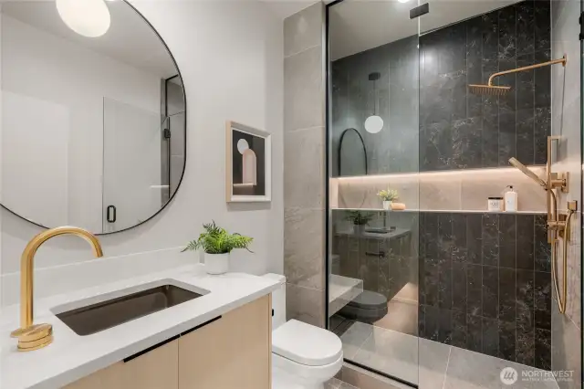 Sleek Shower Space: Enjoy the large, modern tiled shower featuring an illuminated niche for a touch of elegance and convenience.