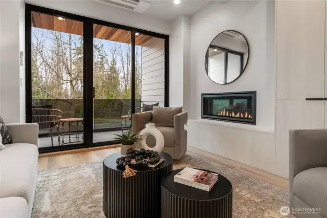 The large living area features a cozy fireplace and sliding glass doors that open to a spacious deck, perfect for seamless indoor-outdoor living.